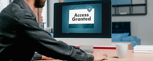 Man looking at the computer with an access granted message displaying